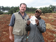 Thika, Kenya Expedition - Worker displaying the hole in a roof piece from one of the greenhouse smashers.