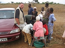 Thika, Kenya Expedition - Local kids removing Black Jacks from Mike's boots.